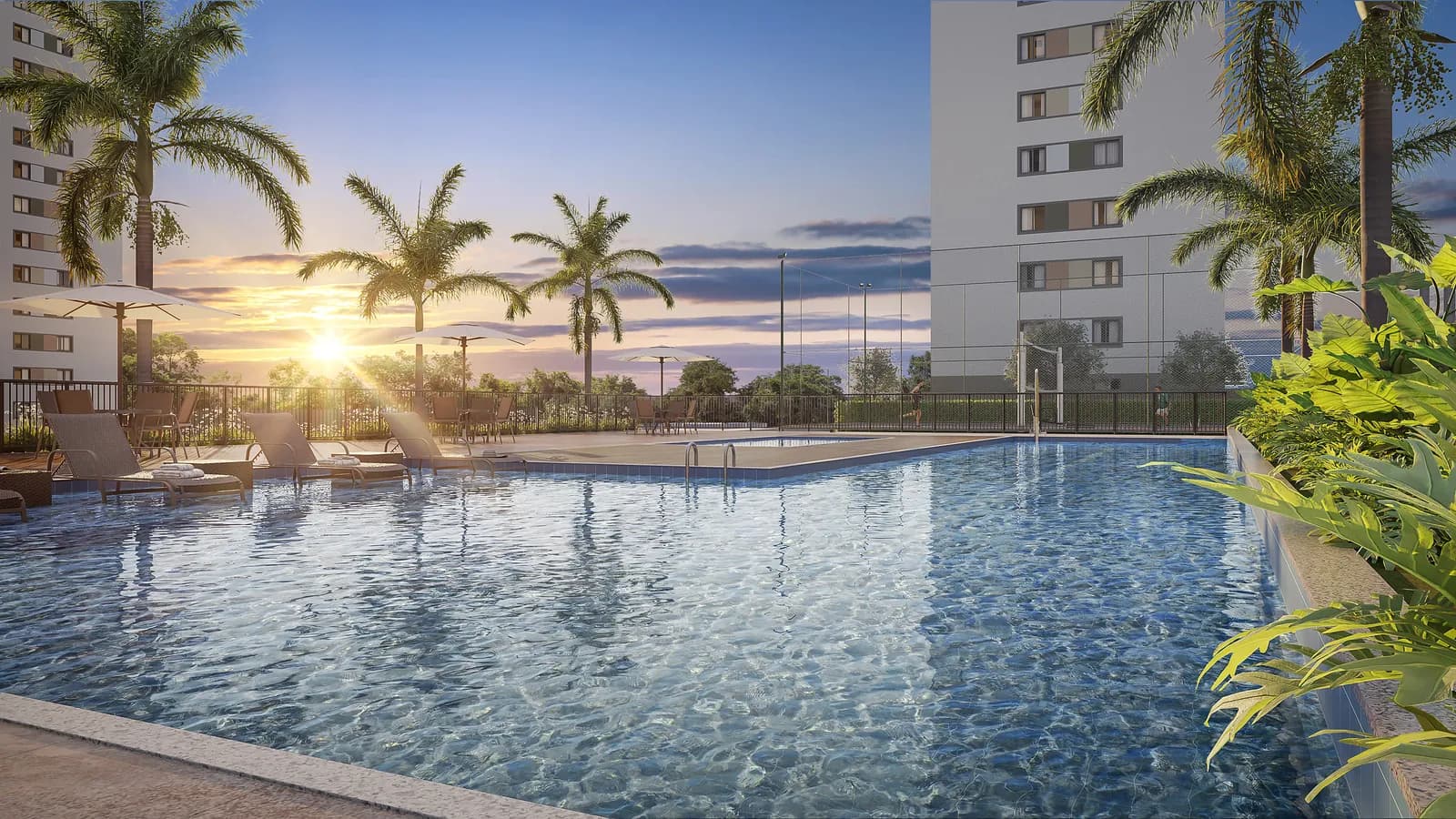 Piscina do condomínio ao pôr do sol, cercada de palmeiras